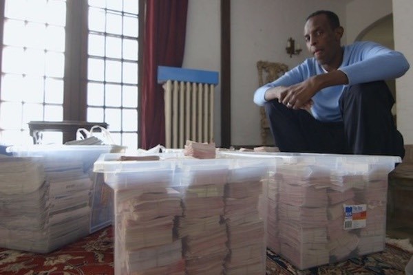 Adam Osmond Sitting Next to Bins of Tickets